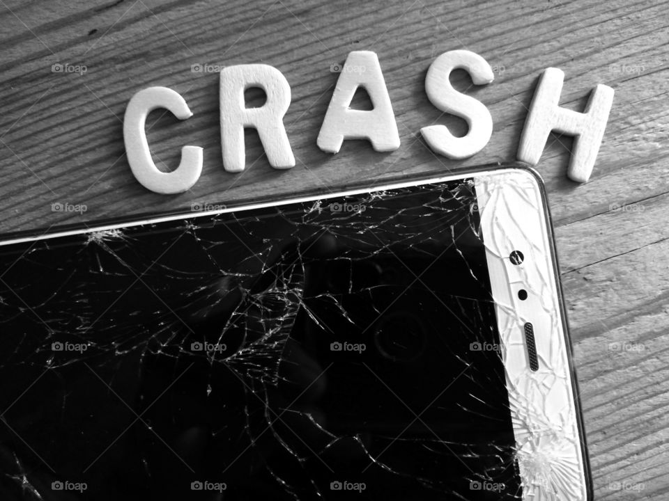 Cellphone with broken and written glass: "crash"