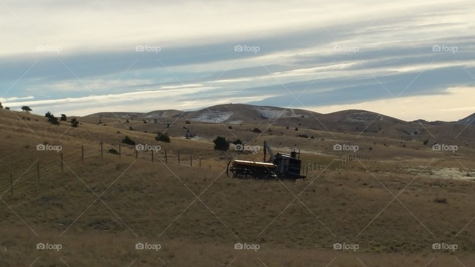 farm equipment in a field with mountains in the background