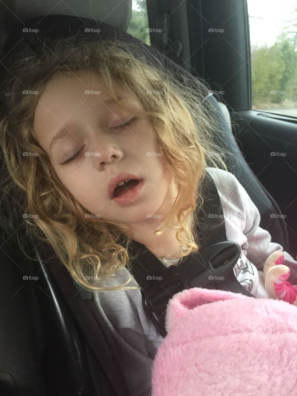 Little girl sleeping on seat in car