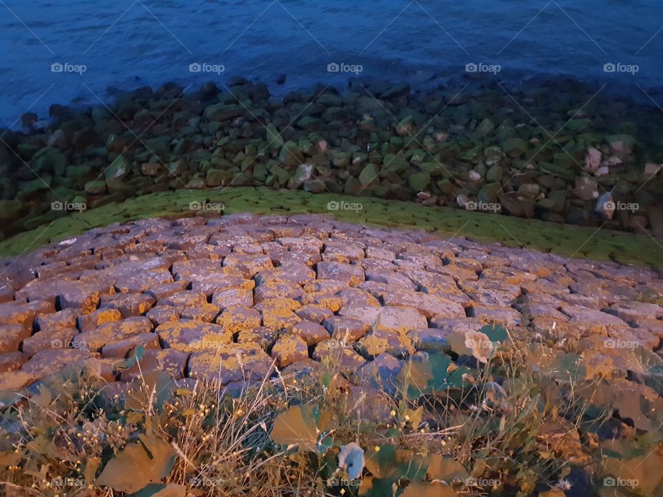 Sloping stone edge towards the water. The photo was taken in the evening. NATURE - OUTDOOR