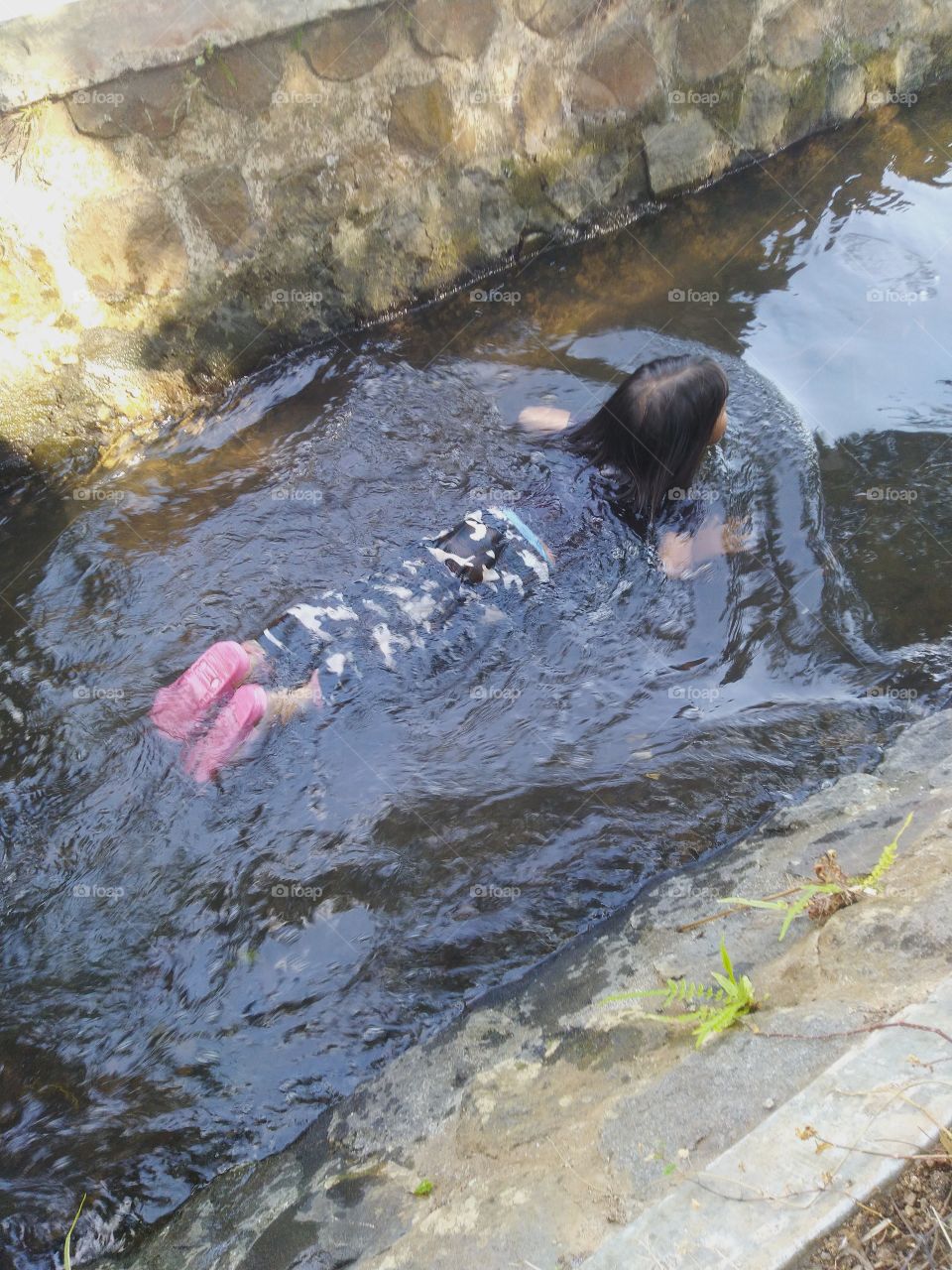 The little boy was bathing in the river