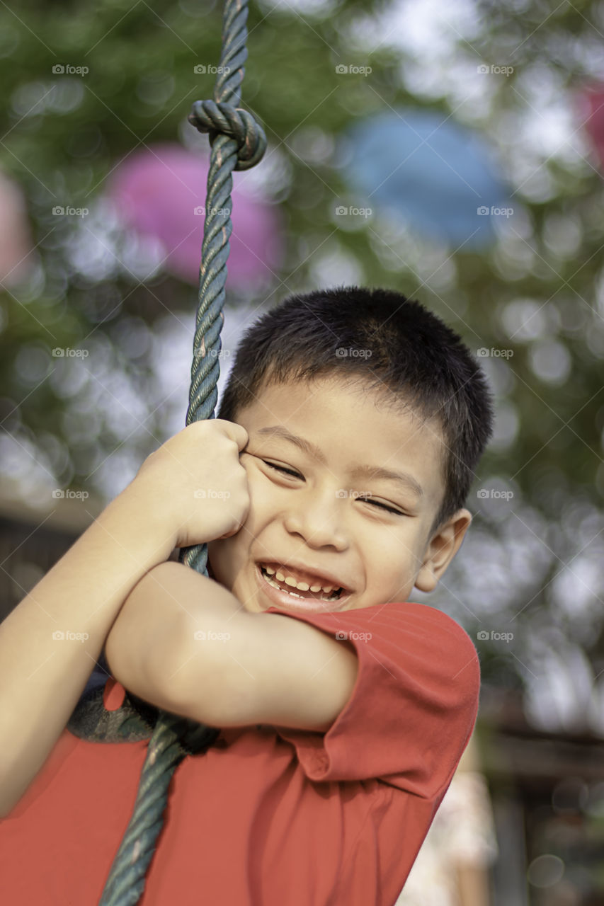 Asean boy at the nodes the rope and smiling happily.