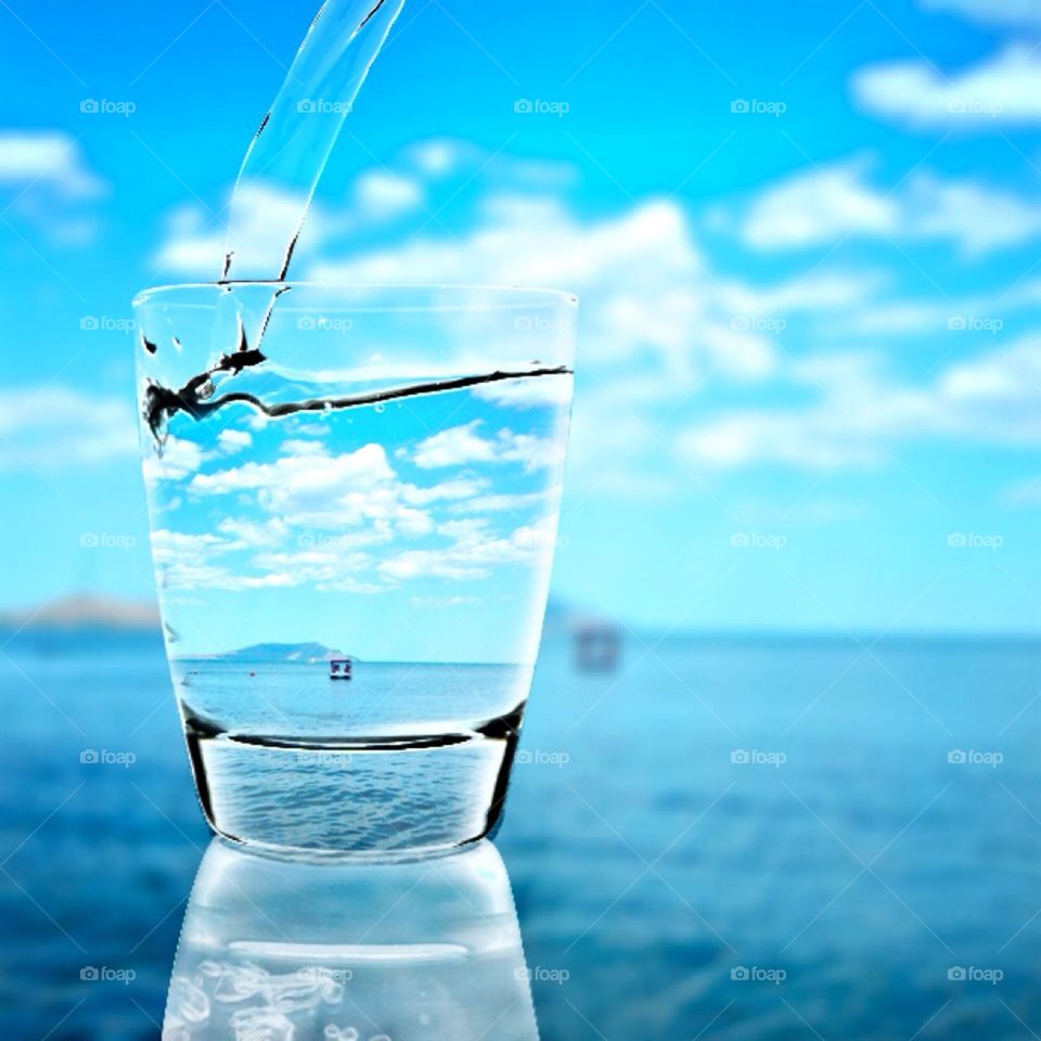 Water being poured in glass near the sea