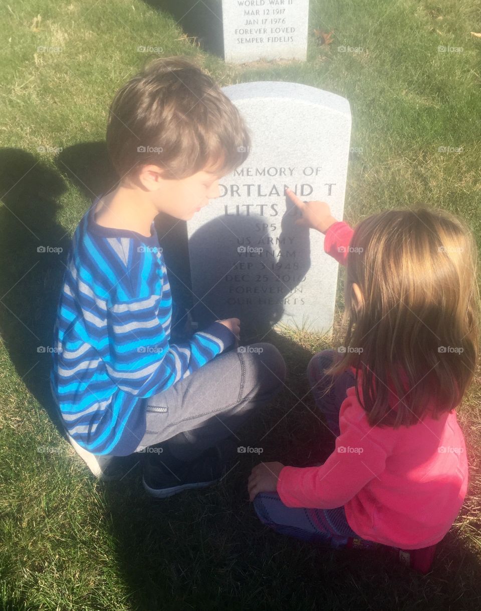 Sister showing text on gravestone to her brother
