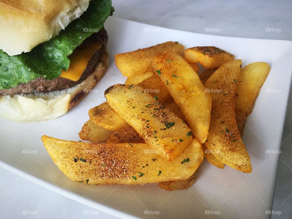 Seasoned French fries with a cheeseburger