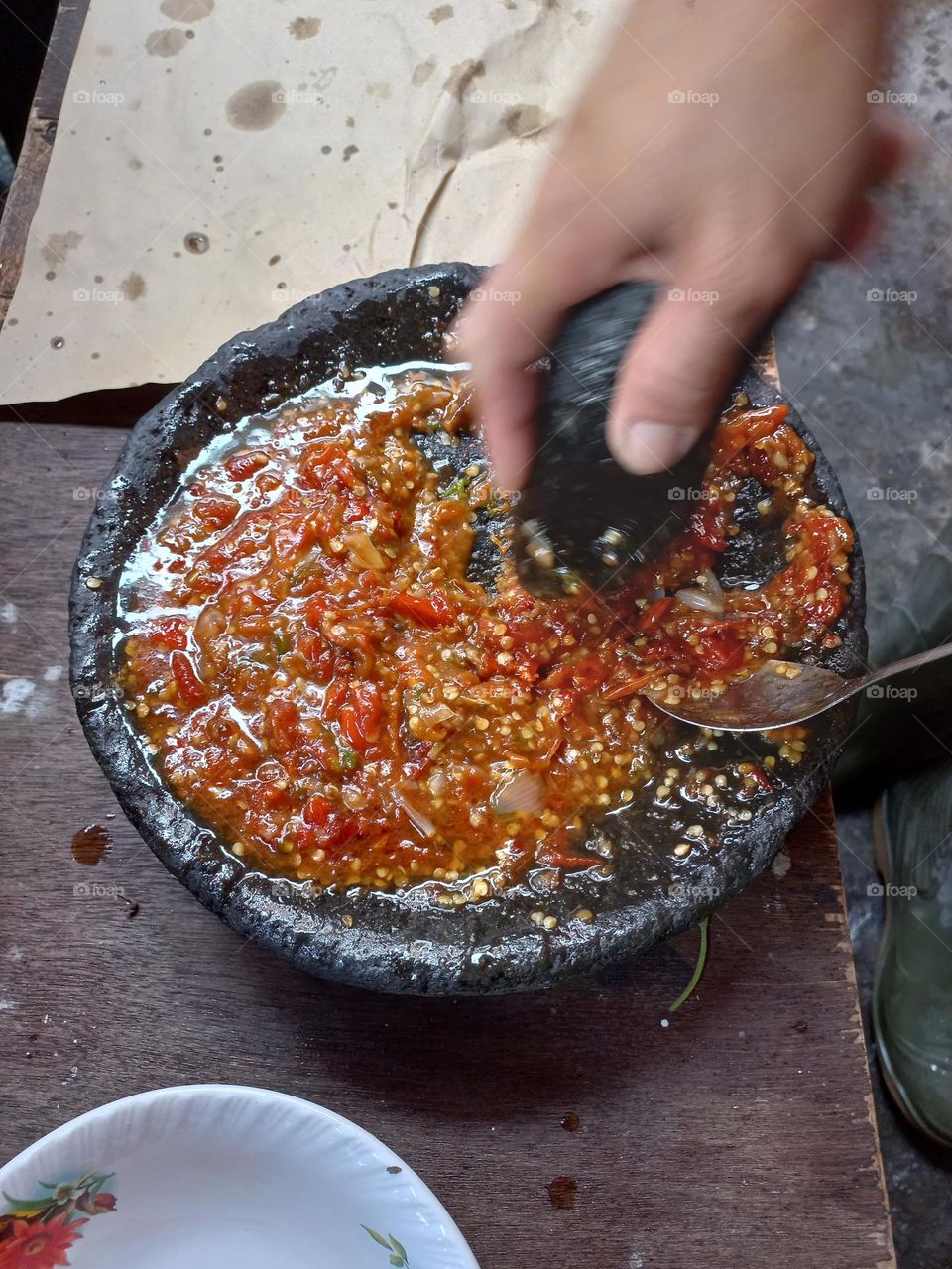 The main chili sauce is crushed so that the chili juice is released and other ingredients such as salt and shrimp paste are added