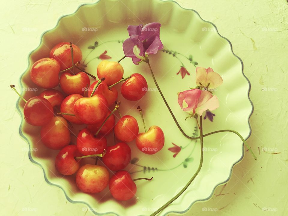 Cherries and sweet peas on decorative dish