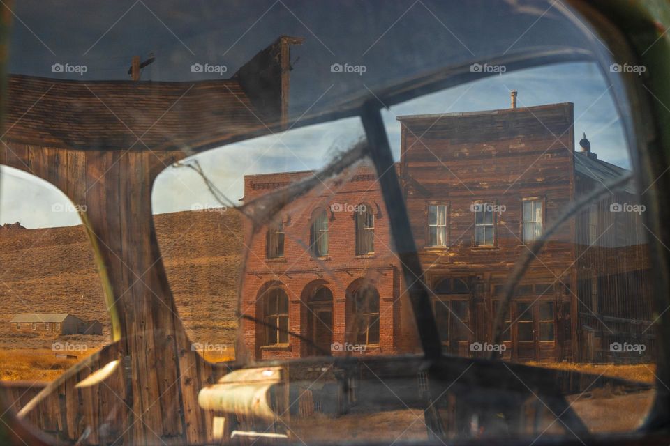 View through broken truck window onto old Wild West town in the US.
