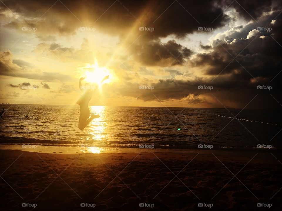 Silhouette of person jumping at beach