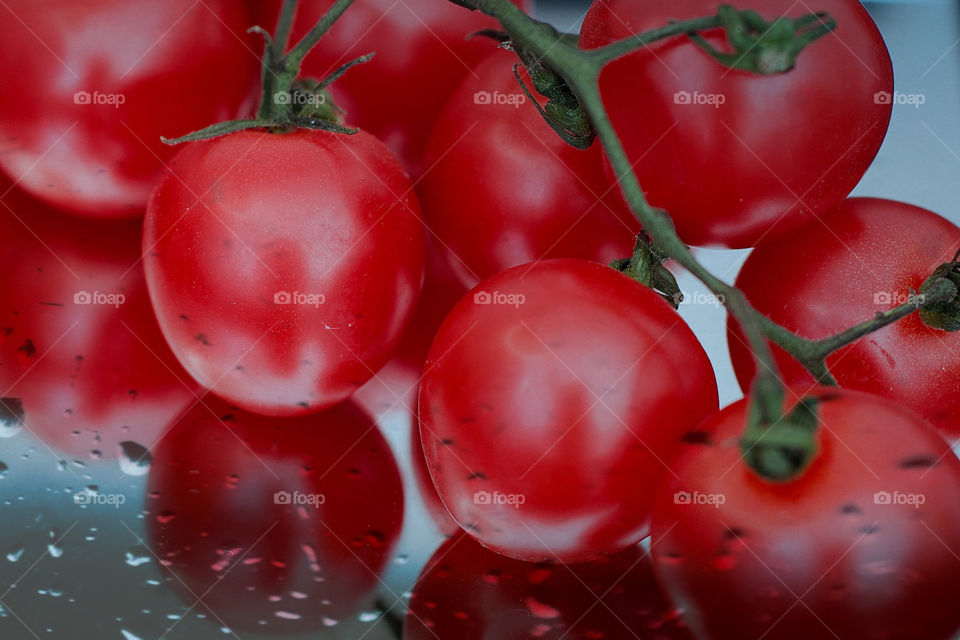 Red tomatoes with reflection and drops of water. 