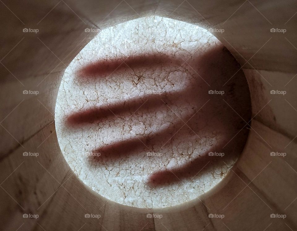 hand on top on a bongo made of wood and animal skin