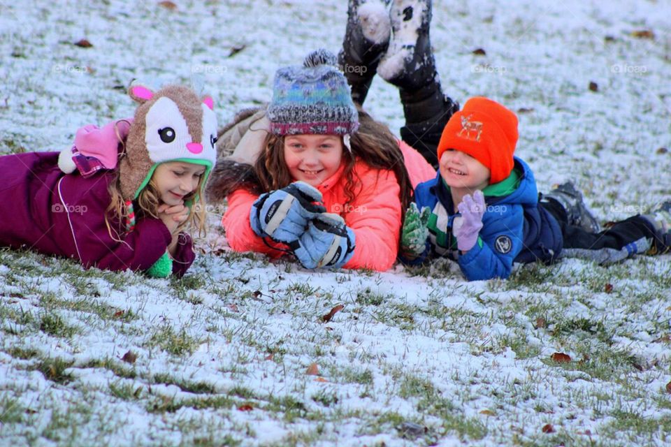 Children lying on snowy land