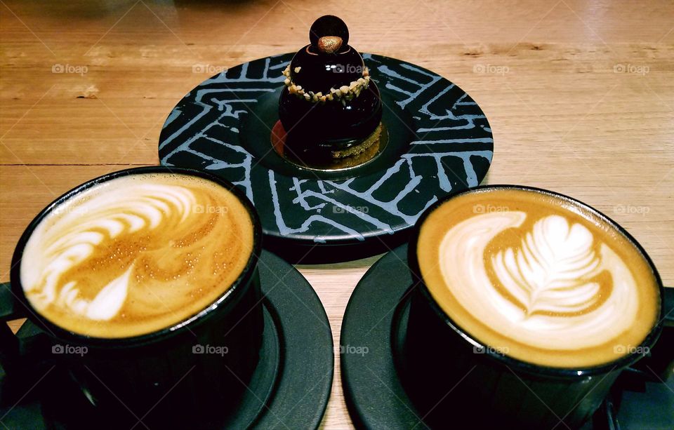 Cups of cappuccino on wooden table