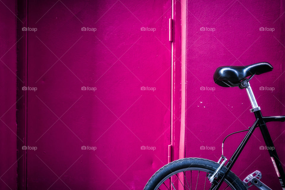Close-up of bicycle against pink wall