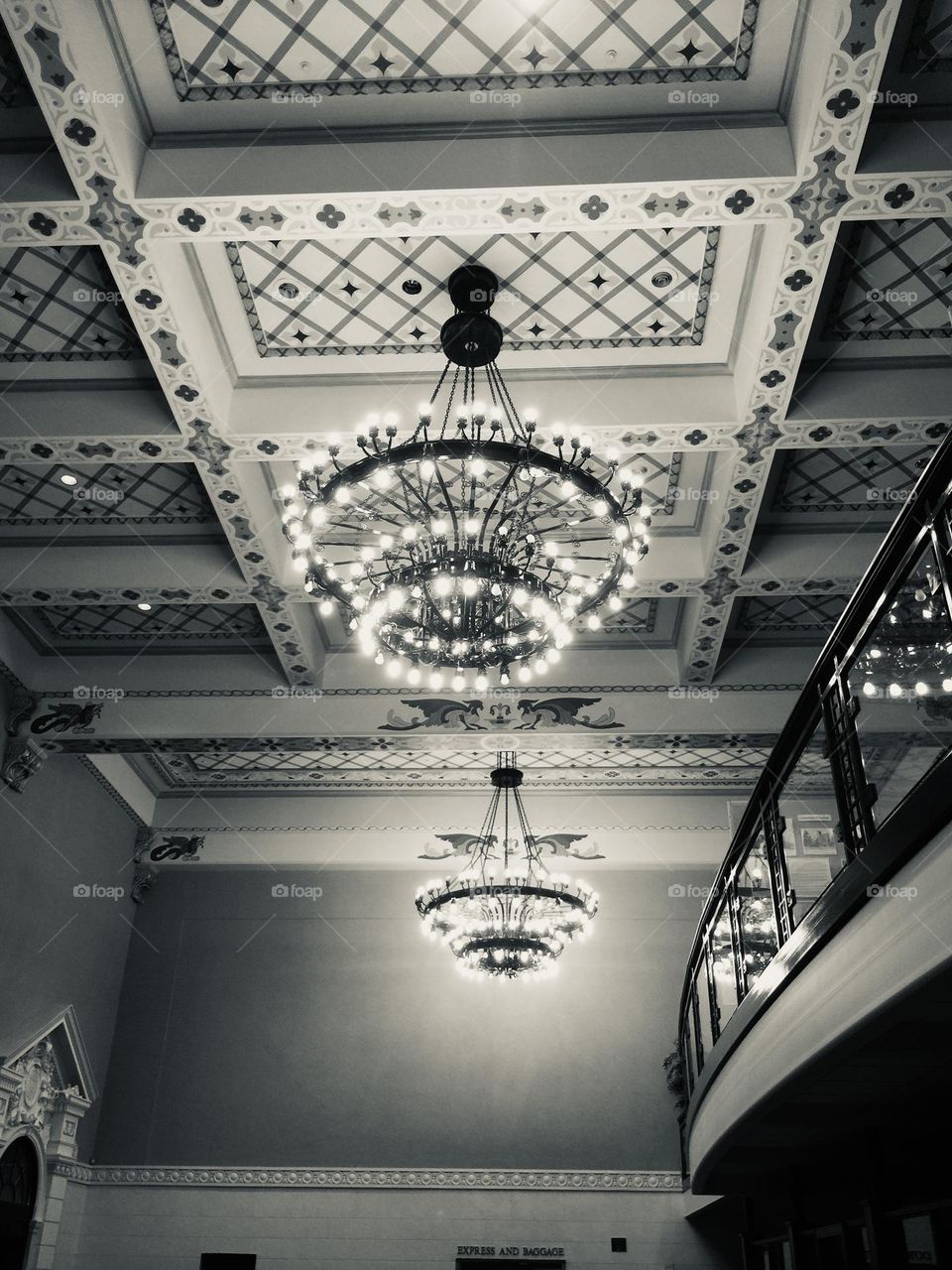 Black and white photo of chandeliers in old train station