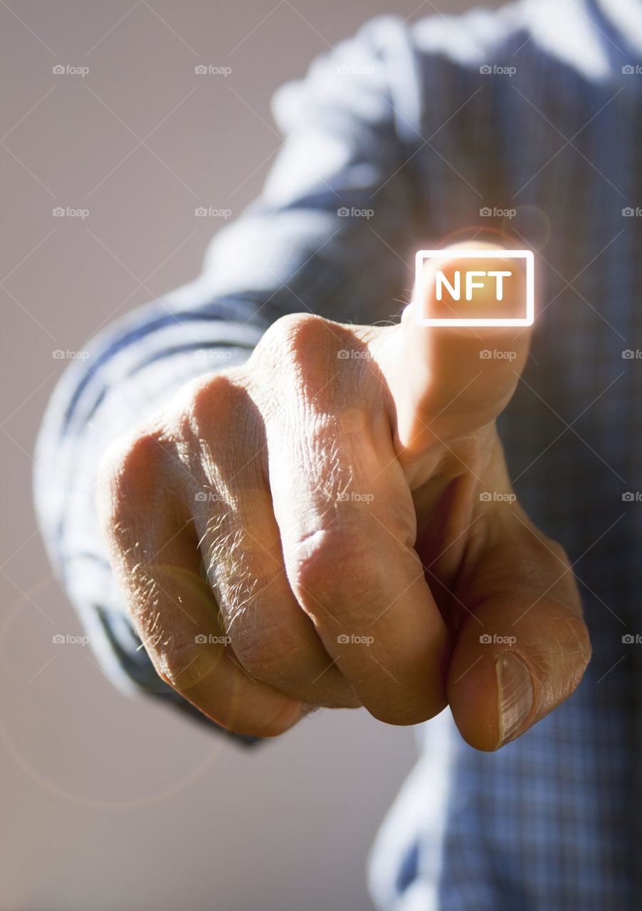 Man hand pressing virtual NFT button