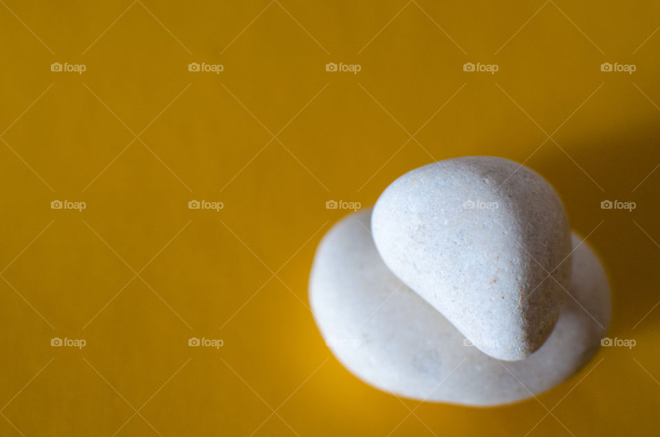 Stack of white rocks on yellow background