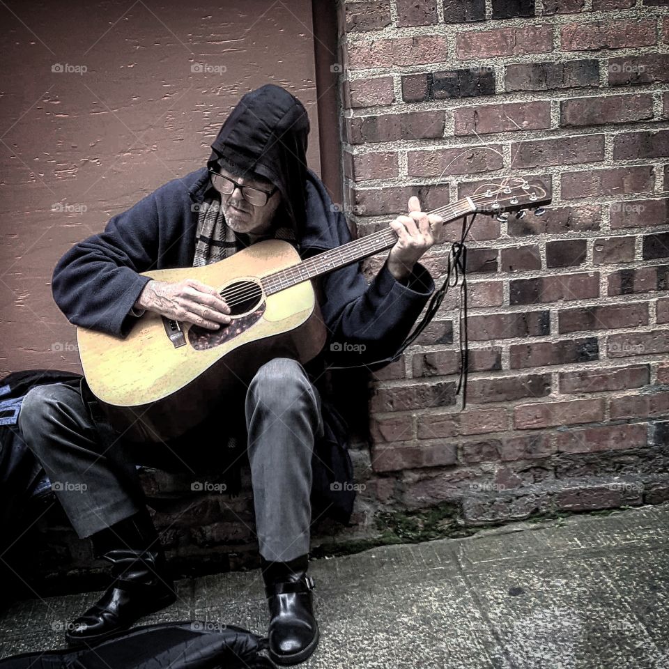 A busker plays his guitar in Seattle's Post Alley in Pike Place Market.