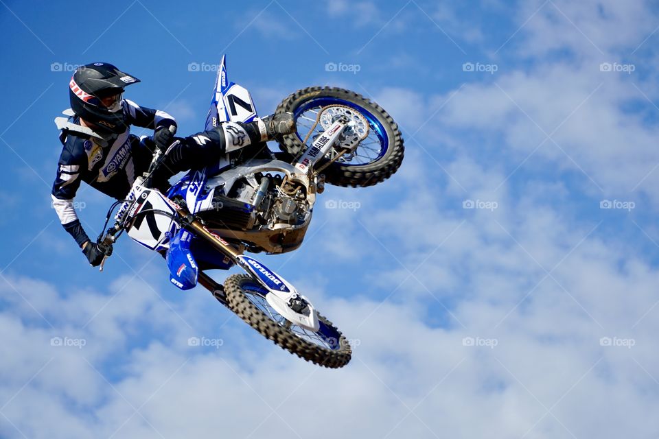 Motocrosser controlling his motorcycle fling through the air