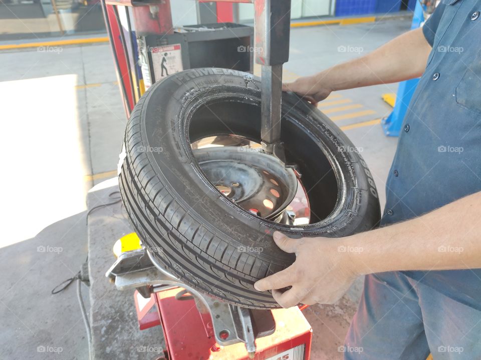 A worker removes the tire from the rim