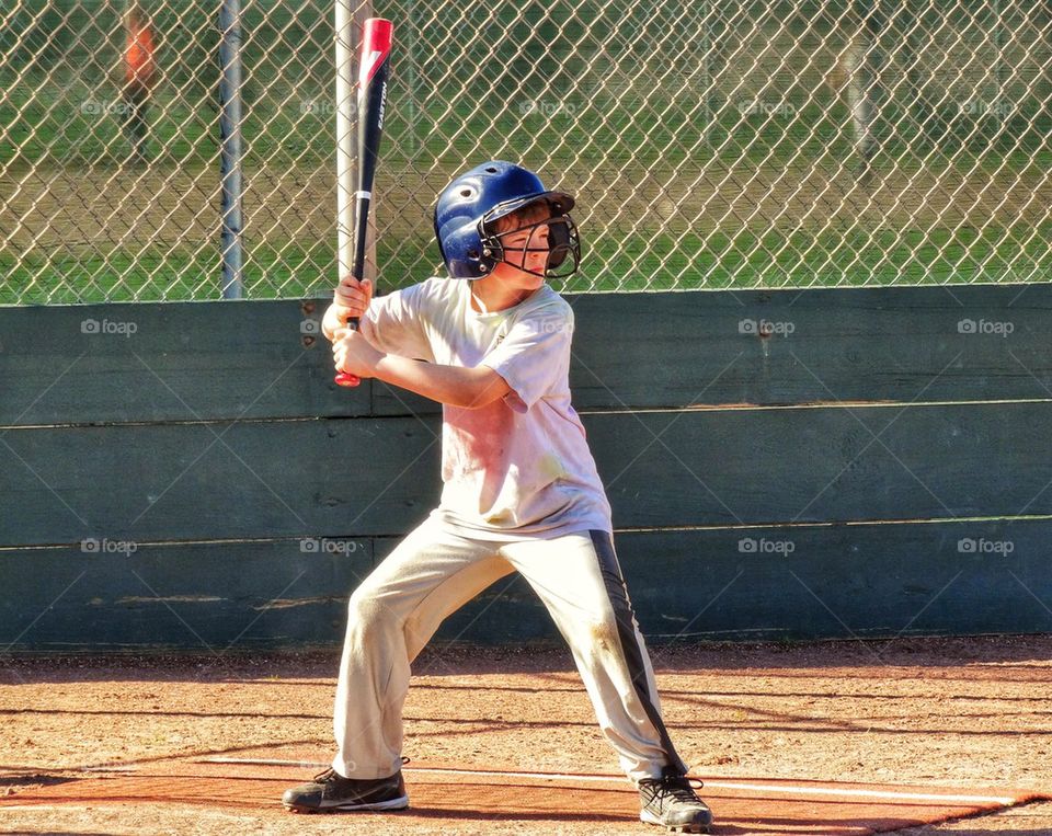 Young Baseball Player At Bat. Focus And Concentration At Home Plate
