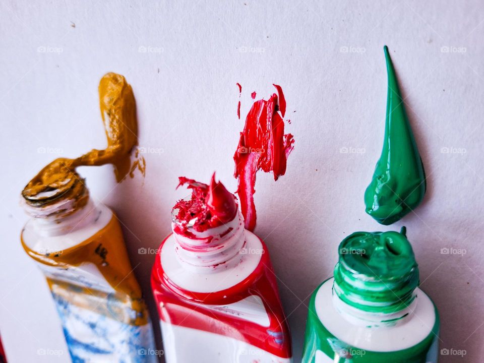 aesthetic photo of empty acrylic paint tubes with colored spots on paper