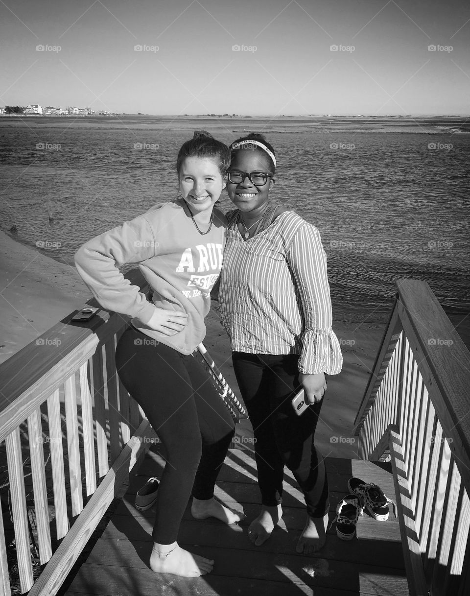 Best buds.  Teenage girls posing on an early spring day at the seashore.  Black and white shot to capture the lights and shadows. 
