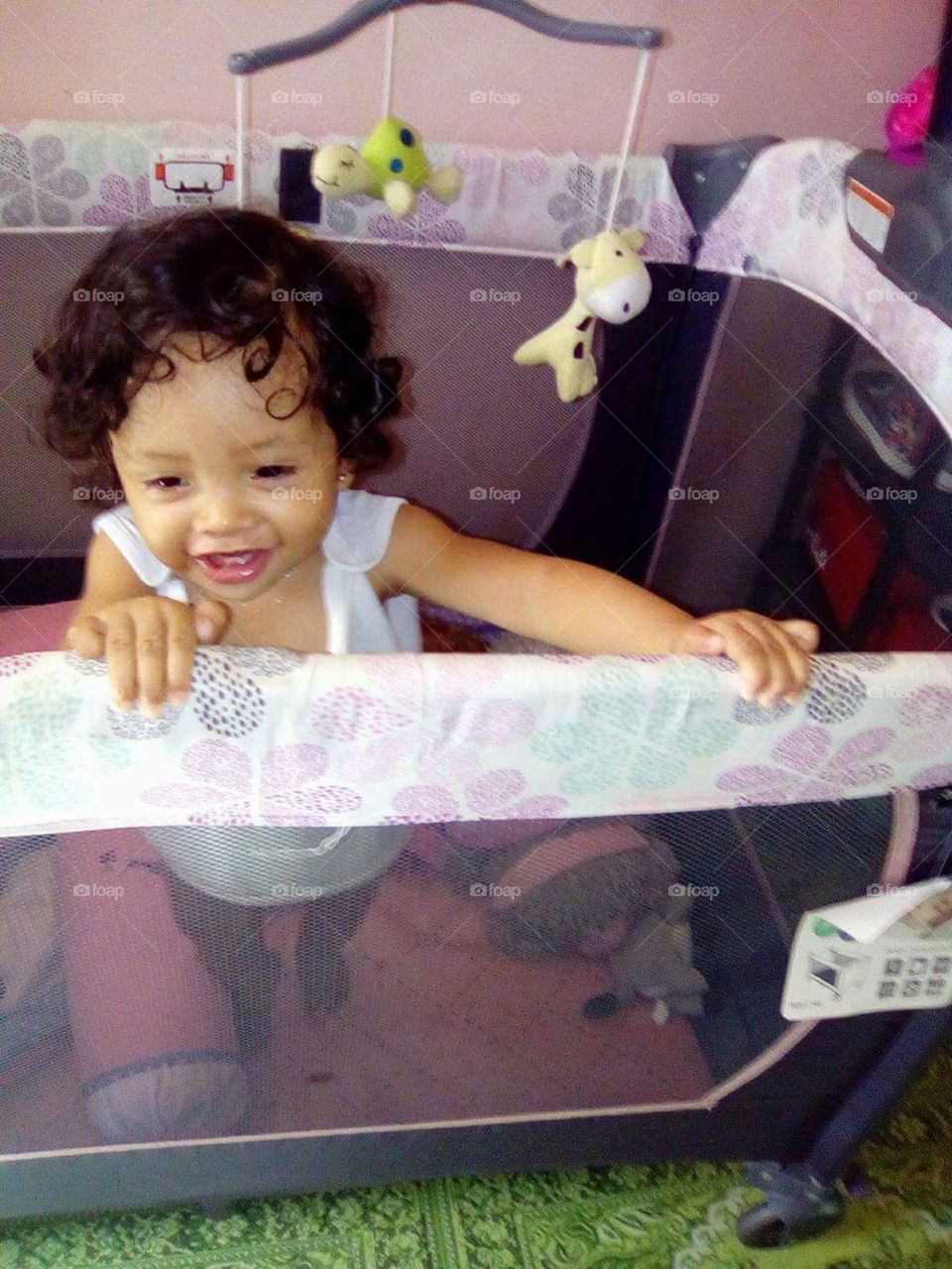 Mary st aged 5 months enjoying her toys in her lovely cot.