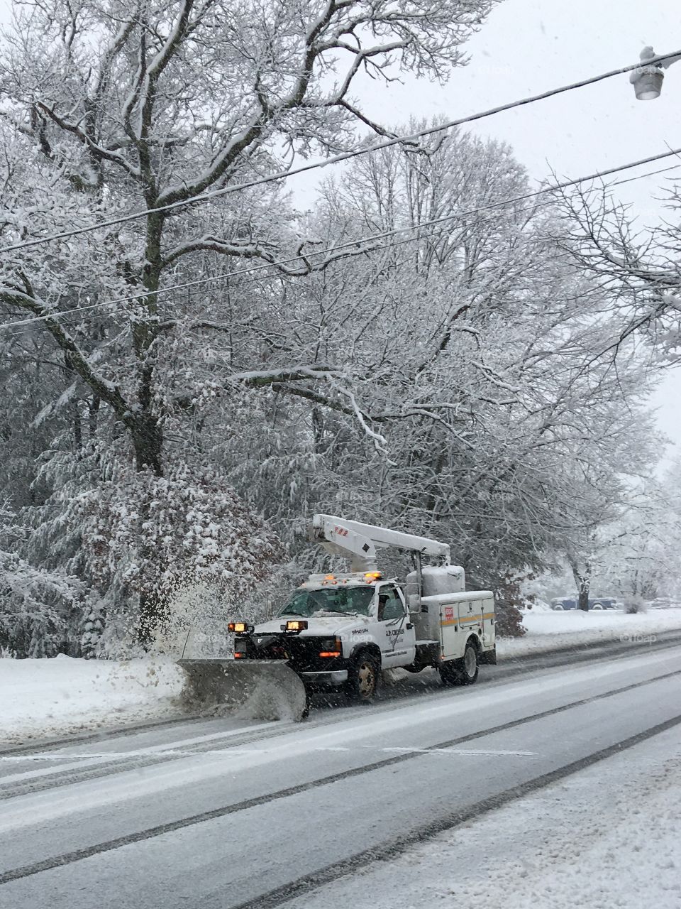 Truck Plowing Street During Snowstorm
This truck was plowing but also had a bucket lift checking wires at tops of telephone poles as he went along.