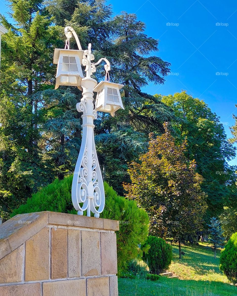 White decorative antique lanterns on a stone wall in a  natural environment