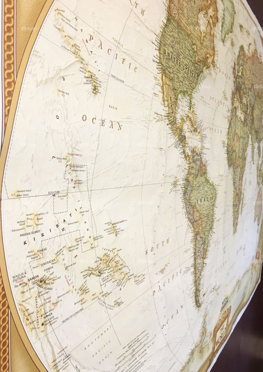 Vintage style map showing Western Hemisphere on a dark maroon wall. Geographic map inspiring travel 