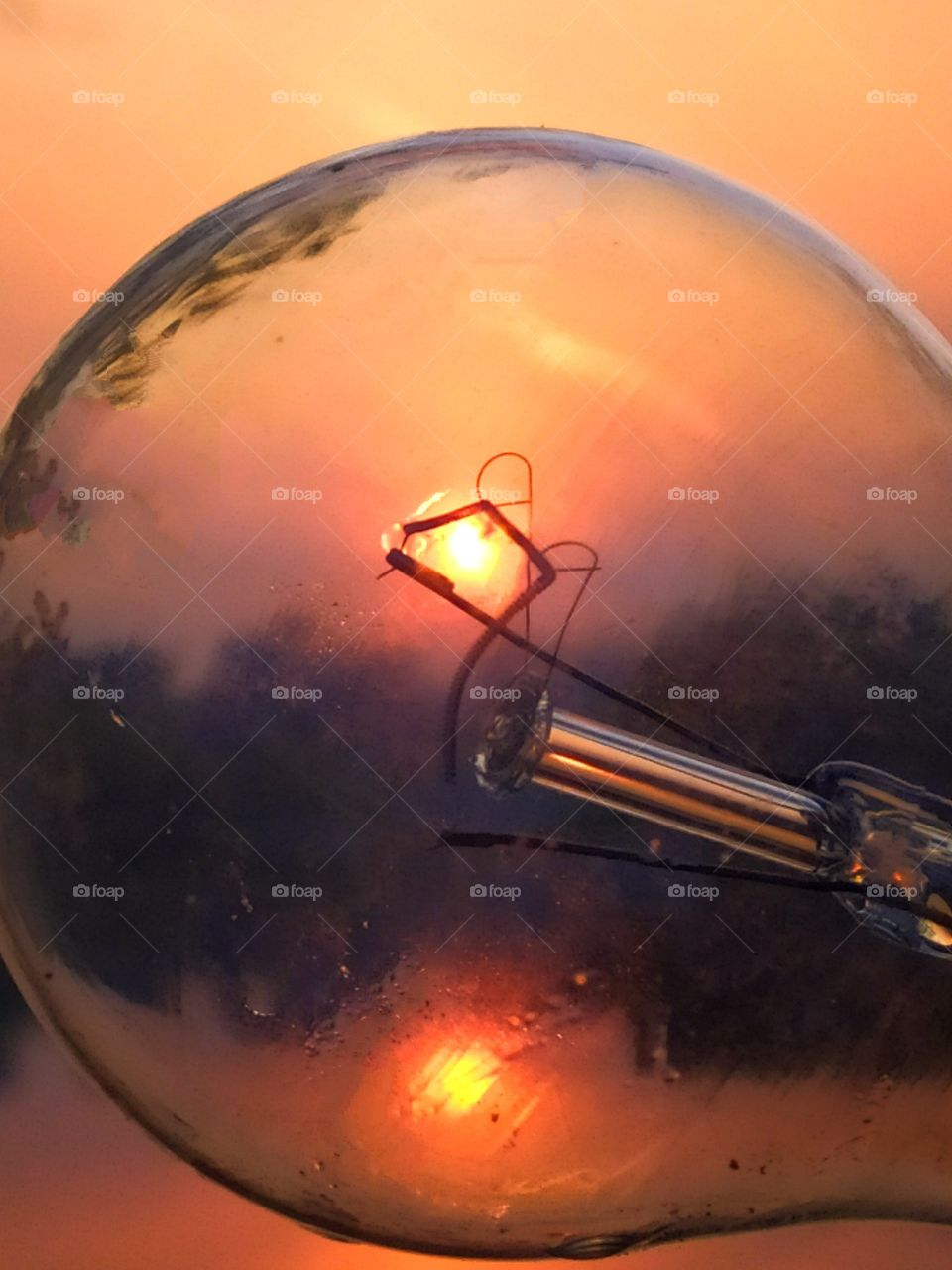 Dawn over the river.  Orange sun through a light bulb in a filament