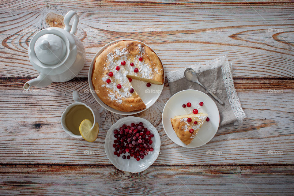 Cheesecake with cranberries and sugar on wooden background