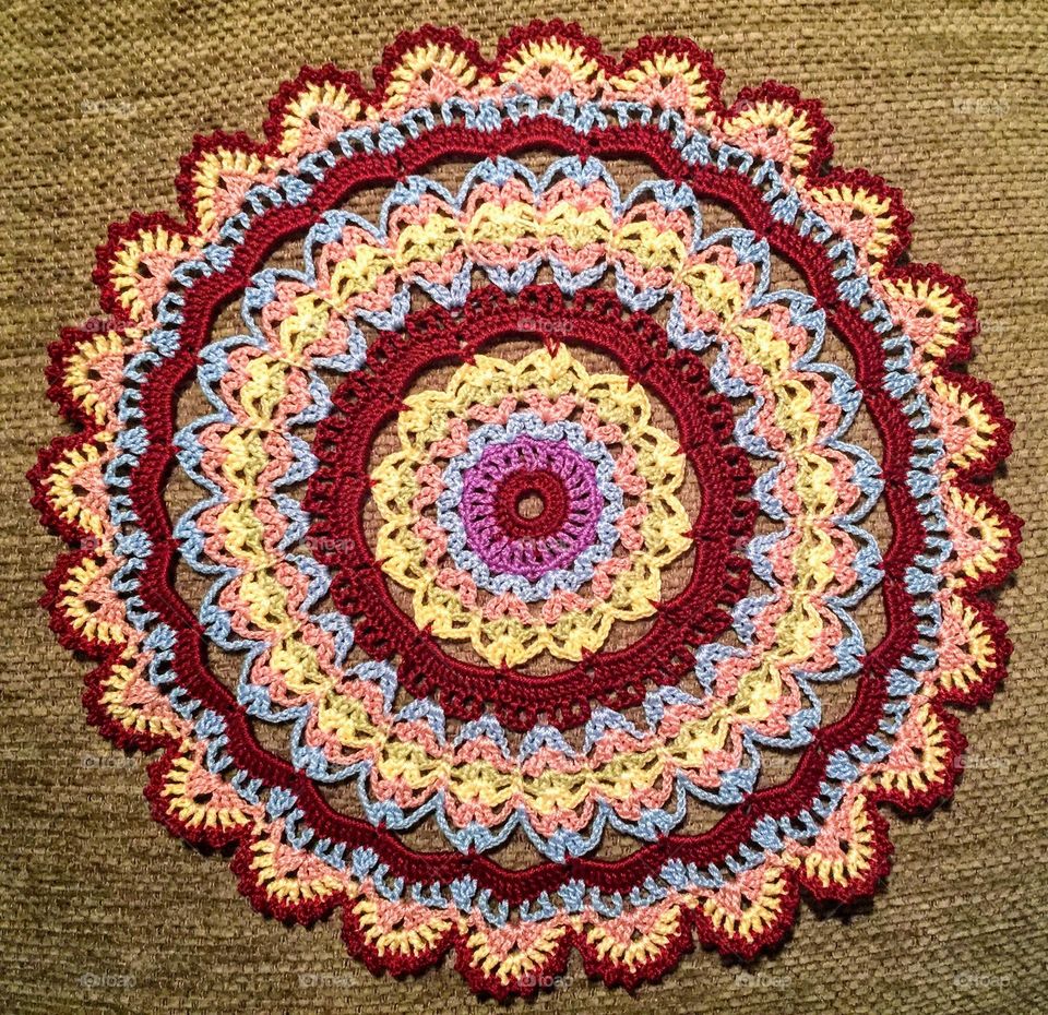 Close up of the multicoloured round circle shaped handmade crocheted table napkin