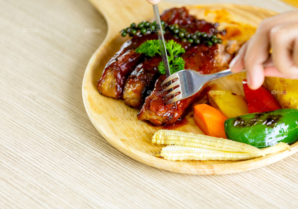 BBQ pork ribs and mix grilled vegetables ob wooden plate