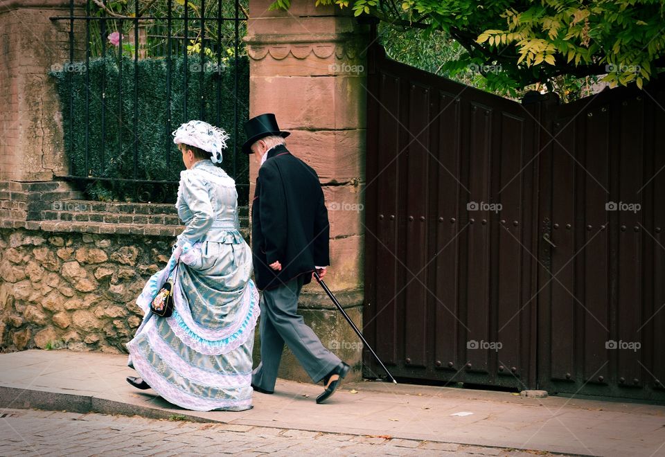 Older people wearing 19th century fashion.