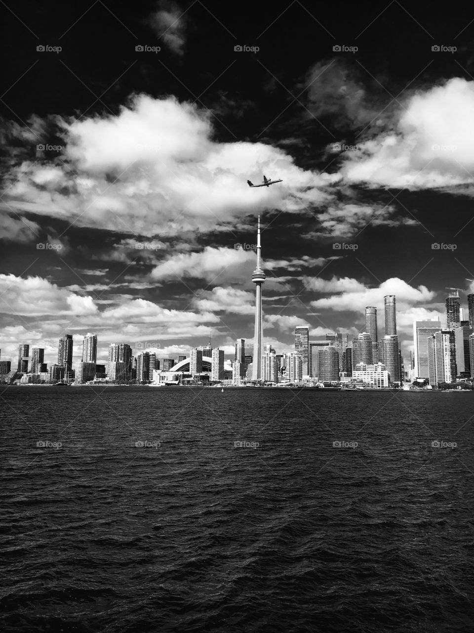 Toronto cityscape with airplane flying over the Toronto tower in black and white 