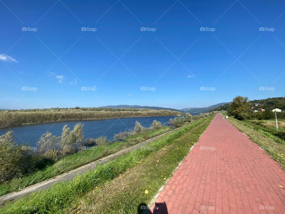 Sunny day by the lake litre trips in Europe Poland. Beautiful blue sky and water, stroll by the shore. 