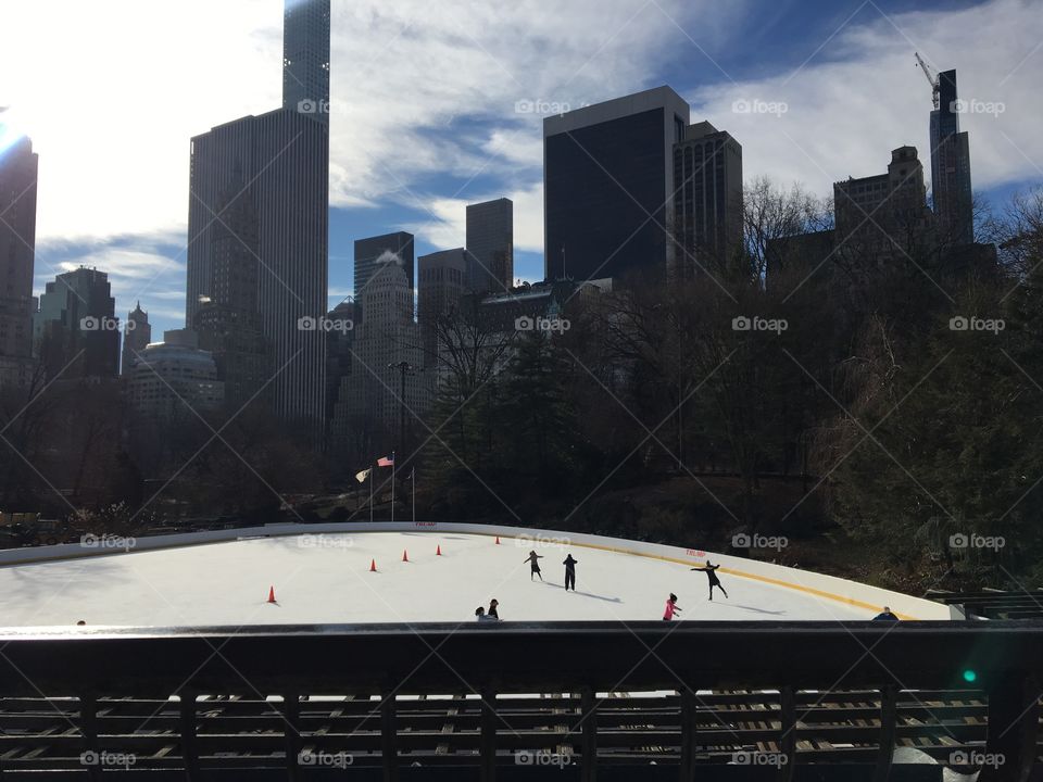 Ice skating rink in Central Park with a beautiful view of the skyscrapers in the city