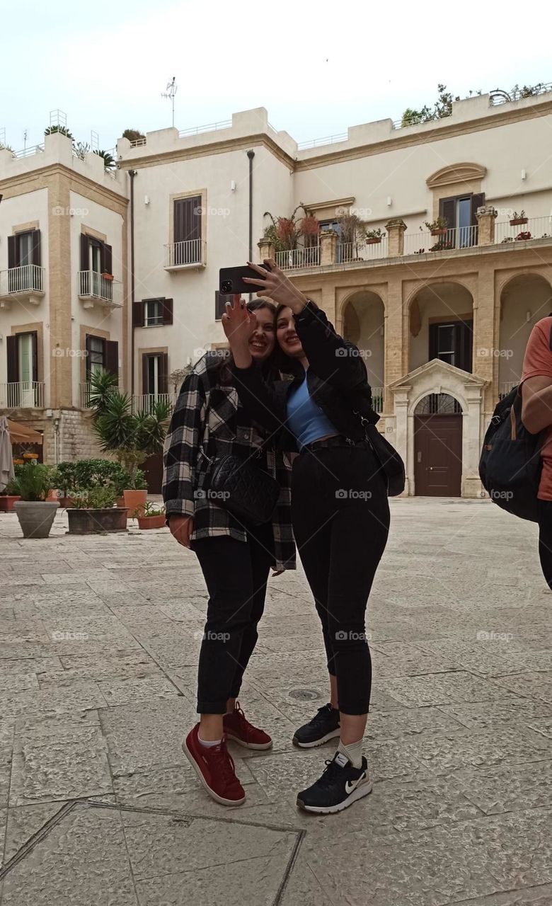 Taking a selfie with a friend / Using a phone / people on their phones / Selfie photo in Italy