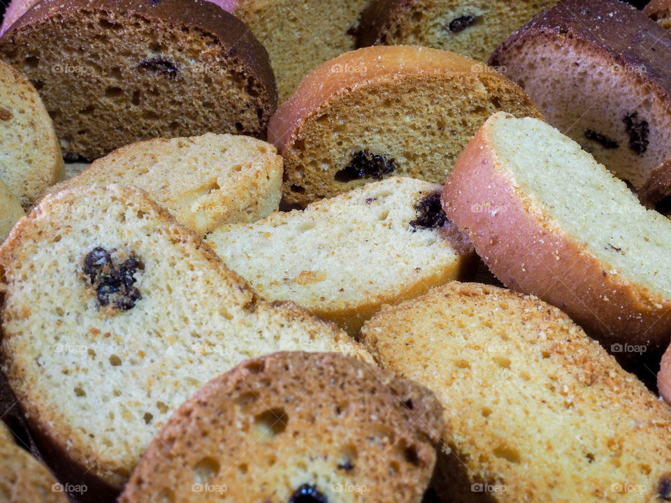 Freshly baked vanilla tasty crackers with raisins lie on a wooden table top and a dark background