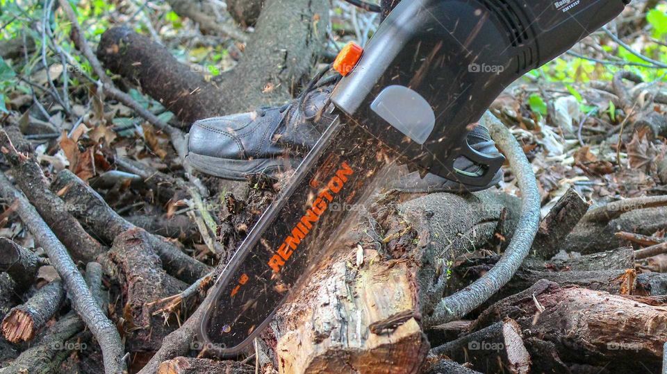 Cutting logs with a Remington electric chainsaw