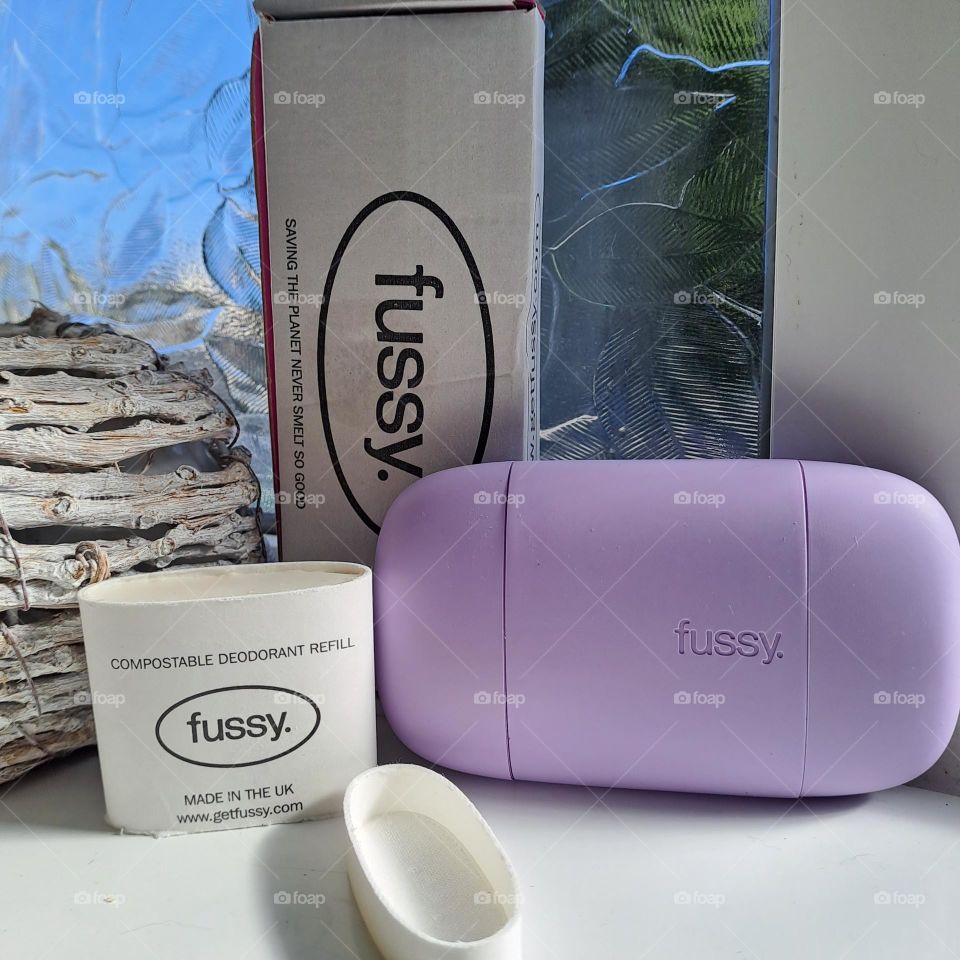 Fussy deodrant brand. lilac roll on stick  and refills displayed on windowsill.