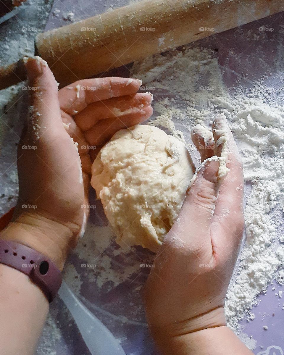 The process of kneading the dough on a pastel purple board