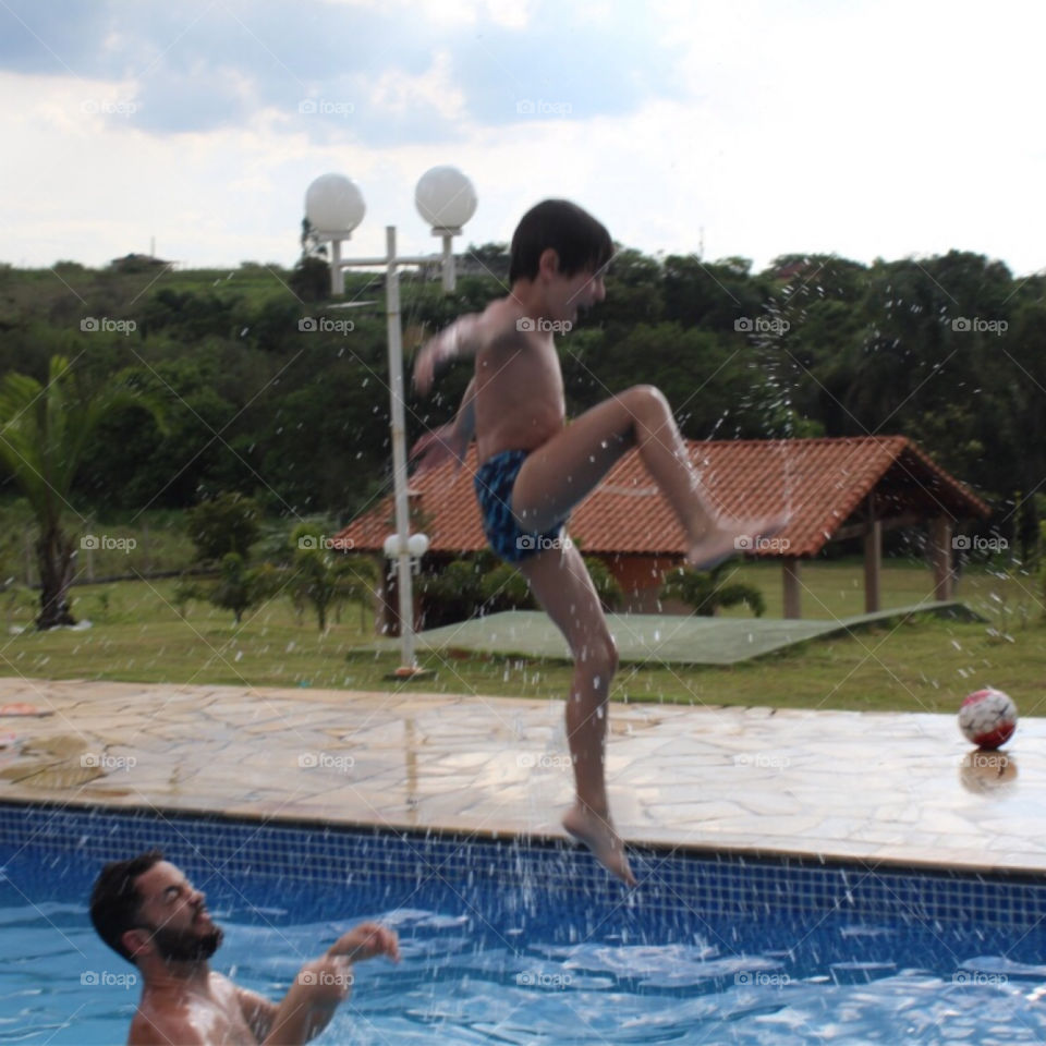 Dad and son enjoying inside the swimming pool