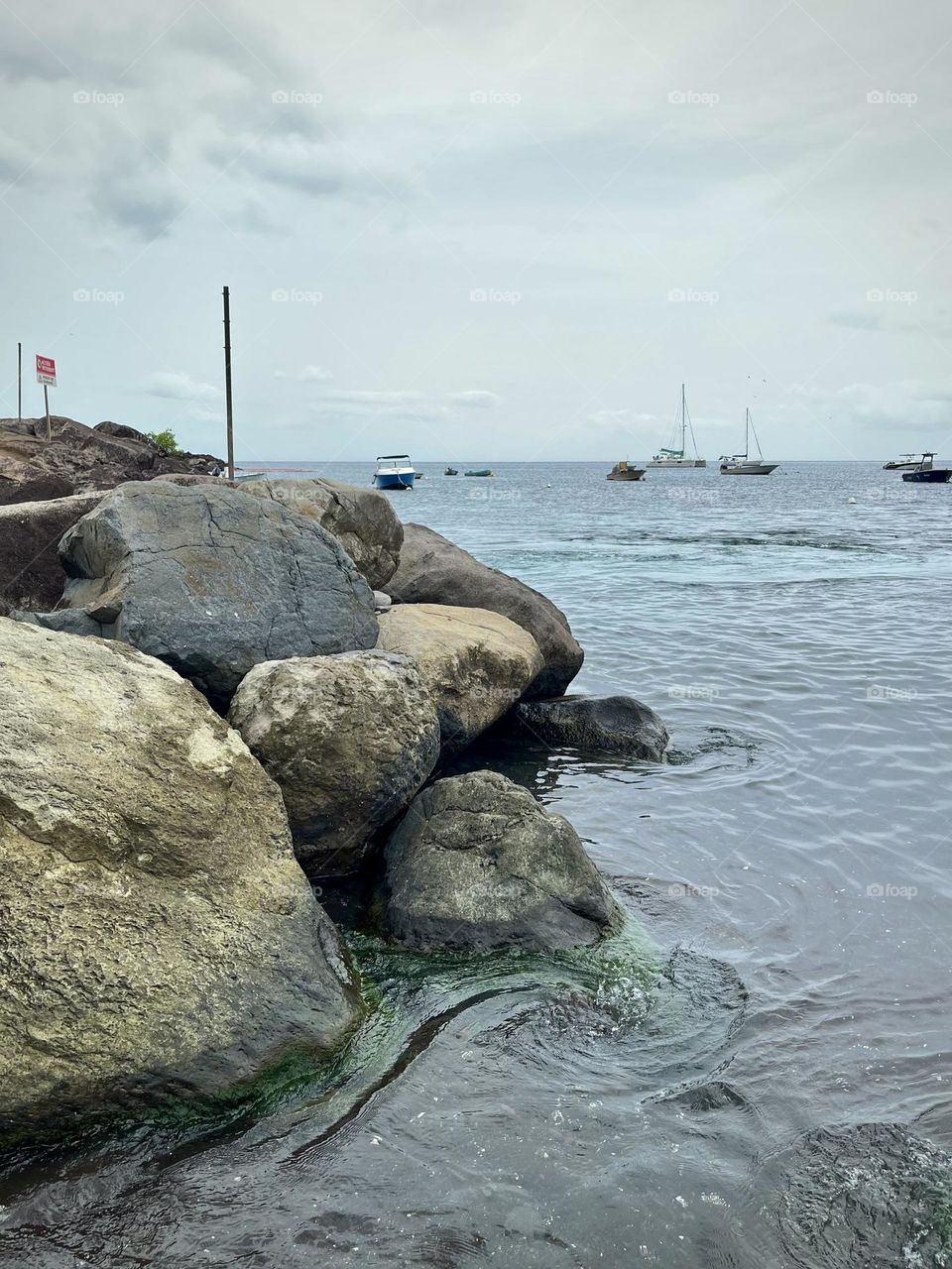 Rocky seaside of the Caribbean with boats moored in the background
