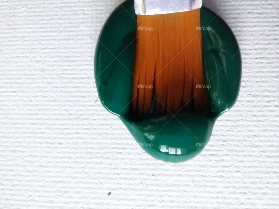 Unfiltered, beautiful, lovely close-up of green paint and a paint brush