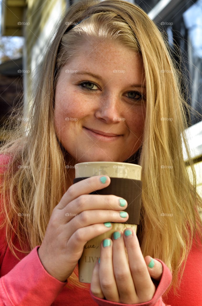 Smiling blonde woman holding ceramic glass