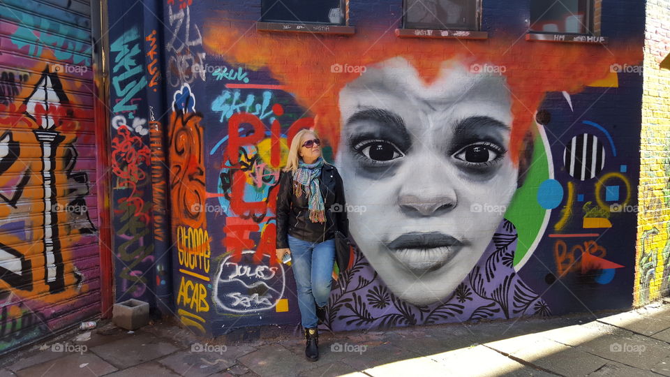 Woman standing in front of graffiti wall