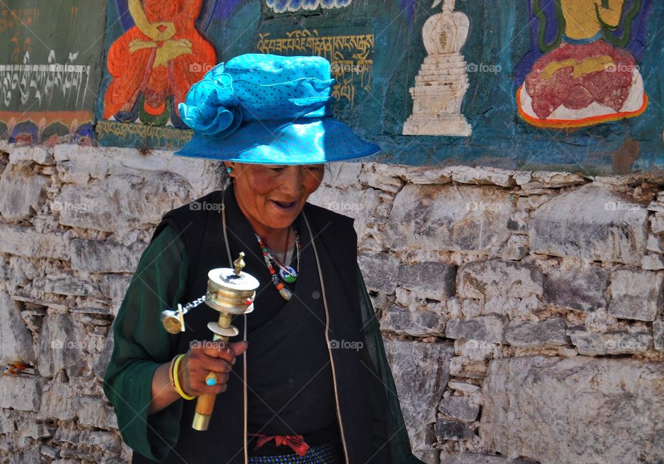 tibetan woman in traditional dress making kora - ritual in buddhist monastery in tibet